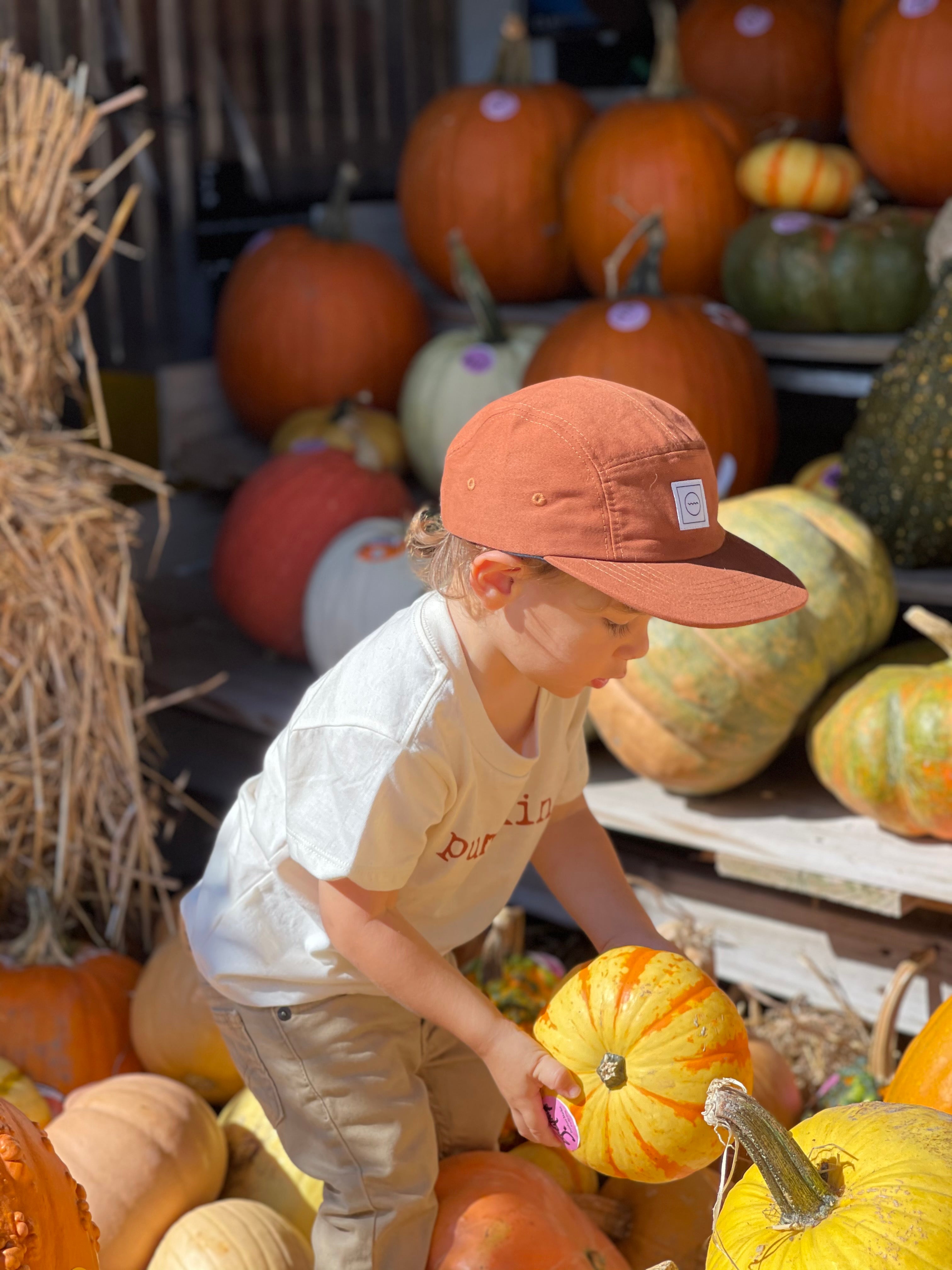 Roman modeling the Rust Five-Panel Hat